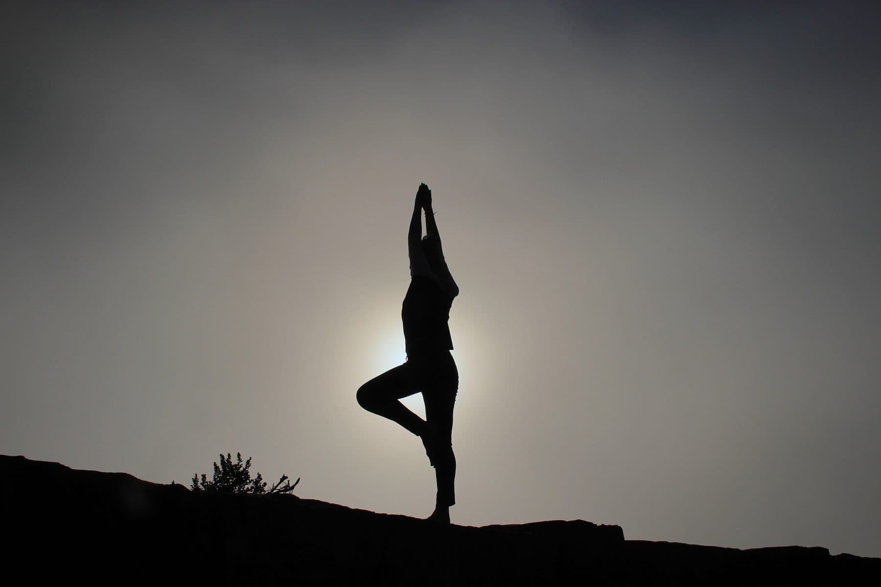 A person in a balance pose in silhouette